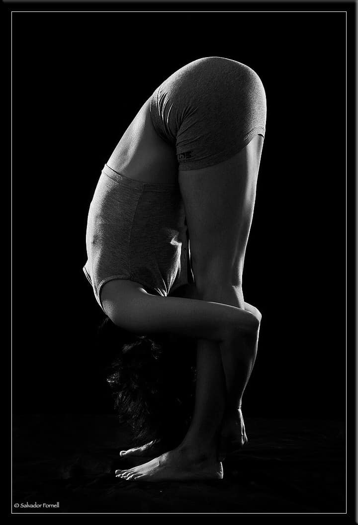A woman in grey top practicing uttanasana that improves mental health